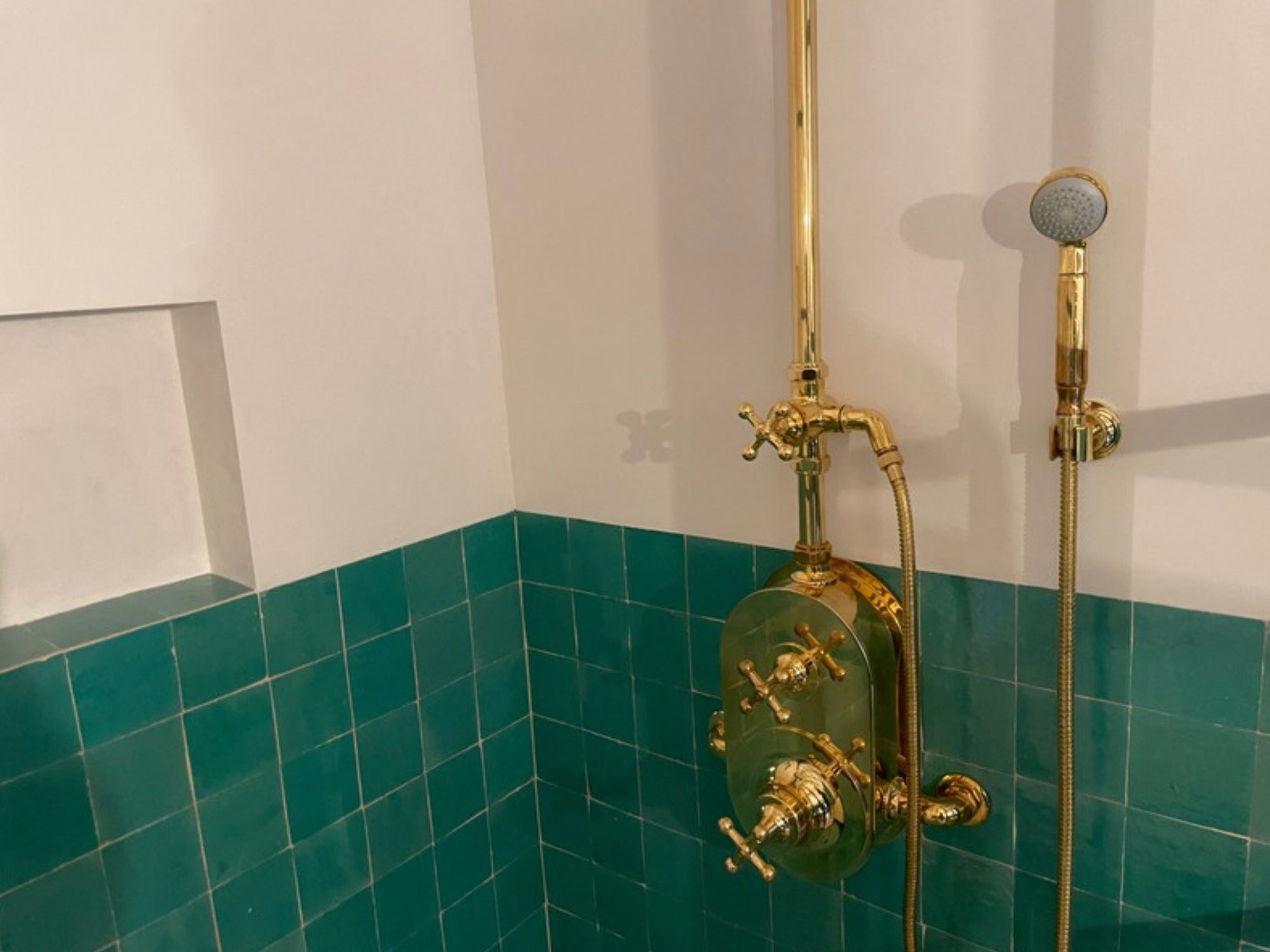 Aqua zellij shower walls with brass fixtures
